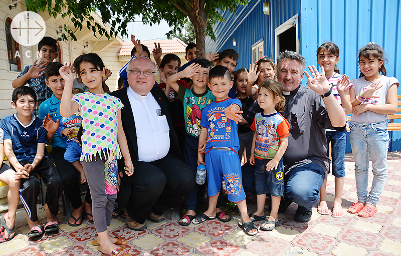 ACN 중동지역 프로젝트 파트너이신 할렘바 신부님 그리고 더글라스 바지 신부님, 이라크 아르빌 난민 캠프의 아이들과 함께(출처=ACN 자료사진)