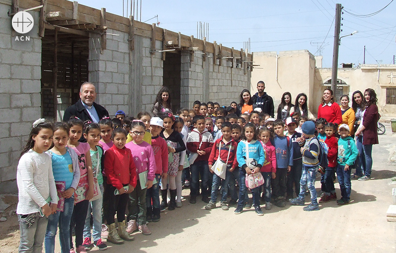 새로 지어지는 교회 건물 앞에서 서있는 아이들 (출처=ACN 자료사진)