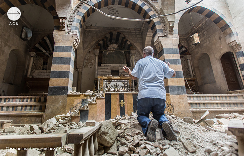 파괴된 성전 앞에서 기도하는 남성(출처=ACN 자료사진)